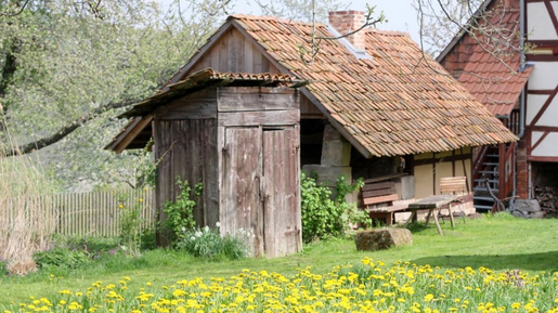 Alte Hütte vor kleinem Haus